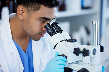 Image showing Science, futuristic and a man with microscope in a lab for medical research and analysis. Serious, medicine and a scientist doing a check of chemistry, microbiology or a virus working at a clinic