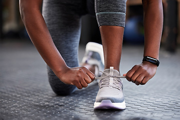 Image showing Hands, shoelaces or shoes at gym with woman, fitness or starting workout, wellness or training. Ready, footwear closeup or girl with sneakers for exercise, performance or health motivation in studio