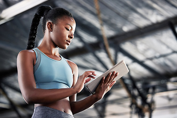 Image showing Black woman, typing or personal trainer with a tablet for fitness training, workout or sports exercise. Progress results, digital technology app or gym instructor planning a online coaching schedule