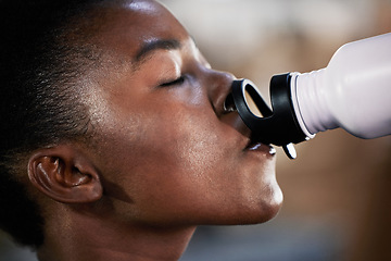 Image showing Face, fitness or black woman drinking water in gym after training, workout or exercise to relax or hydrate body. Tired, fitness or tired girl with bottle for healthy liquid hydration on resting break