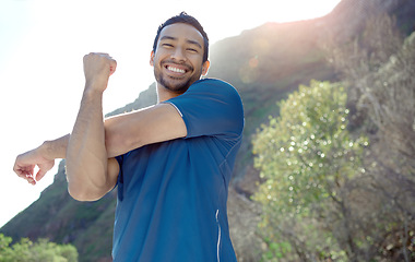 Image showing Fitness, portrait and stretching with a man runner outdoor in the mountains for a cardio or endurance workout. Exercise, sports and smile with a young male athlete getting ready for a run in nature