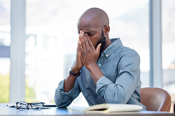 Image showing Mental health, businessman with a headache and at his desk of his workplace office. Anxiety or burnout, problem or mistake and African male sitting with stress or sad at his modern workstation