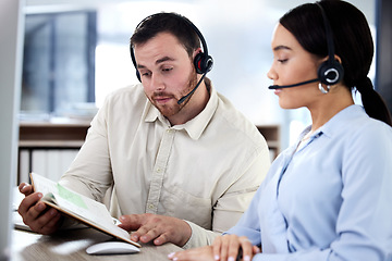 Image showing Call center, colleagues reading a notebook and headset at their desk in a modern office. Collaboration or teamwork, partnership or support and help with coworkers with a book together at workstation