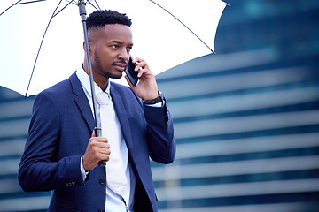 Image showing African business man, phone call and umbrella in city, street and communication on walk, travel and winter. Black businessman, smartphone chat and rain in urban metro, cbd and contact for networking