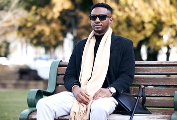 Image showing Blind black man, park bench and relax with sunglasses, walking stick or outdoor by trees, peace or thinking. African guy, vintage fashion and young person with disability, glasses or travel in nature