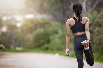 Image showing Nature, woman and warm up from back, workout motivation and fitness while stretching legs. Dedication, commitment and girl runner standing on road with leg stretch for outdoor run and exercise goals.