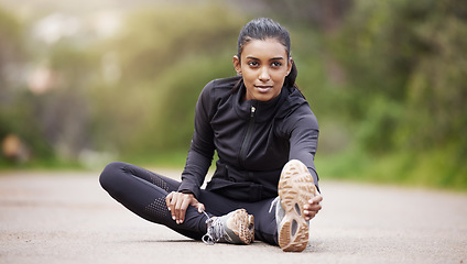 Image showing Nature, warm up and woman stretching legs while sitting, workout motivation and fitness mindset with hands on feet. Focus, commitment and girl on floor, leg stretch for outdoor run and exercise goals