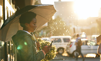 Image showing Umbrella, phone and black woman in a city, rain and connection with mobile app, network and chatting. Female person outdoor, weather and girl with a cellphone, contact and communication with cover