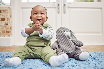Image showing Smile, baby and black child clapping in home, having fun or enjoying teddy bear. African newborn, children and toddler, kid and young infant play, happy or applause for childhood development in house
