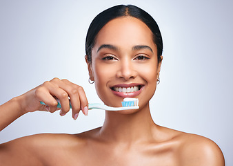 Image showing Woman, brushing teeth and studio portrait with smile for self care, dental wellness or health by white background. Girl, dentistry model and toothbrush with toothpaste, product and happy for cleaning