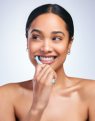 Image showing Woman, brushing teeth and studio with thinking, smile or self care for dental wellness, health or white background. Girl, dentistry model and toothbrush with toothpaste, product or happy for cleaning