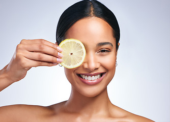 Image showing Woman, skincare and lemon in studio portrait with smile, happiness or natural glow on skin by white background. Girl, model and happy for fruit, cosmetics or youth with wellness, nutrition and shine