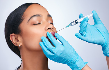 Image showing Woman, studio and needle for lips, surgery and cosmetics for skin, facial or collagen by white background. Girl cosmetic surgeon and filler on face, syringe and hands for beauty, skincare and mouth