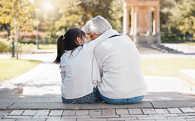 Image showing Girl, grandmother and hug in the outdoor for trust or secret in family with grass and sunshine. Kid, hugging and grandma with back of together at the park with a whisper in summer to relax in nature.