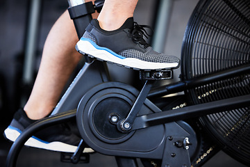 Image showing Feet, fitness and a man on a gym bicycle for cardio, cycling and exercise. Legs, shoes and a person on a bike for sports, health and training with a workout on a machine for physical activity