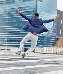 Image showing Happy, jump and business man in city for celebration, success and winner. Excited, promotion and wow with male employee jumping in urban outdoors for achievement, motivation and bonus target