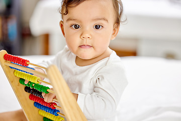 Image showing Abacus, bedroom and baby play with toy for learning, child development and motor skills. Family home, newborn and face of adorable child with educational toys, counting beads and playing in bed