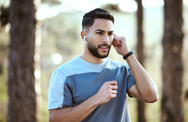 Image showing Fitness, man and outdoor with earphones for music on run or workout for motivation. Male athlete person or runner listening to audio in nature forest for training exercise, running and wellness goals