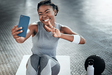 Image showing Black woman, gym selfie and peace with smile on floor for fitness, workout and wellness on social media app. Influencer girl, photography and blog for exercise, icon and health for lifestyle in club