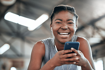 Image showing Phone, earphones and portrait of black woman in gym for fitness, sports or exercise. Smartphone, face and African female athlete on social media break, web and music after workout, training and smile