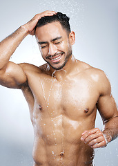 Image showing Man in shower with smile, washing body and happiness, hygiene and healthy person on studio backdrop. Water, skin and hair care, happy male model cleaning with splash on background with bathroom spa.