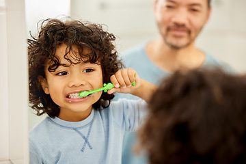 Image showing Face, mirror and child brushing teeth in a family home bathroom for health and wellness. Reflection of a latino boy kid with his father to learn about dental, oral and mouth care with a toothbrush