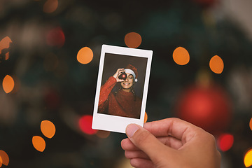 Image showing Hand, christmas and picture with a person looking at a photograph of a memory on a blurred background. Home, nostalgia and holidays with an adult holding a photo to remember past memories on xmas eve