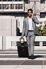 Image showing Phone call, travel and luggage with a businessman walking in the city for a company trip. Mobile, communication or suitcase with a young male employee talking while on a commute outdoor in town