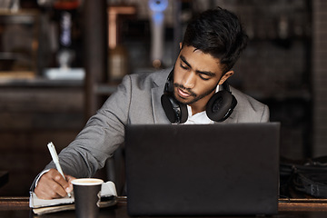 Image showing Young business man, writing and cafe with notebook, laptop or plan for schedule, report and analysis. Indian businessman, book and pen for ideas, brainstorming or web design with focus in coffee shop