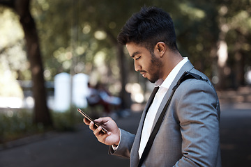 Image showing Phone, search and Indian business man in a city for travel, social media and internet browsing. Smartphone, reading and male worker texting on app, message or tech on commute in a street in India