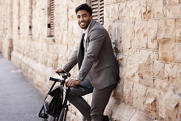Image showing Bicycle, portrait and happy business man in city for carbon neutral, sustainable and transport. Bike, commute and Indian male person on cycling break, smile and relax while traveling in India