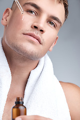 Image showing Skincare, oil and man with serum, dermatology and natural beauty against a grey studio background. Face, male person or model with cosmetics, wellness and spa treatment with grooming routine and glow