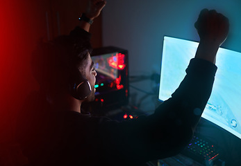 Image showing Man in dark room, video game win with fist pump and online streaming, gaming competition and esports on computer. Achievement, cyber and male streamer celebrate winning gamer tournament with success