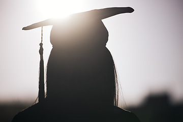 Image showing Graduation, education and silhouette of a student woman outdoor on university campus with lens flare. Future, college and scholarship with a female graduate standing outside at an event from the back