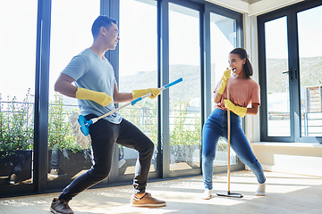 Image showing Couple, singing and cleaning home, dance and having fun playing with mop guitar and broom. Clean, dancing and happy man and woman, singer and chores, housekeeping together and happiness for music.