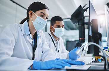 Image showing Science, biotechnology and scientists in a laboratory working on research for a medical project. Face mask, equipment and healthcare researchers with a pharmaceutical experiment, test or analysis.