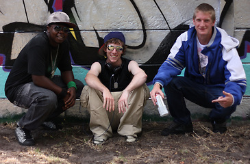 Image showing Graffiti, street art and portrait of friends by wall with spray can for hip hop, fashion and urban. Smile, artist and painting with group of male teenagers in park for grunge, creative and style