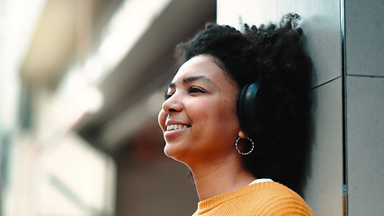 Image showing Music, headphones and black woman happy in city for travel, motivation and mindset. Young person on urban street with buildings background listening and streaming podcast or motivation audio outdoor