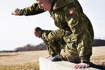 Image showing Soldier in training, military men and jump over a wall in obstacle course for fitness and endurance. Army team in camouflage uniform outdoor, train for war and exercise with mission and action