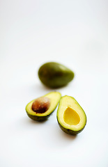 Image showing Avocado half, fruit and healthy food in studio with color, art and creativity for nutritionist. Salad, wellness diet and nutrition with clean, green or vegan ingredient isolated on a white background