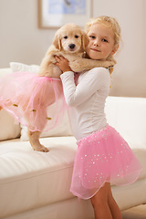 Image showing Child, golden retriever and portrait of a dog and happy girl together for love, care and development. Face of a cute kid and animal puppy in a tutu playing dress up as friends on the home sofa