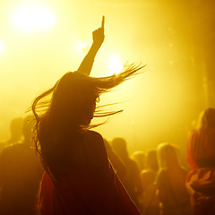 Image showing Dance, rave and female person at a concert, disco event or psychedelic trance festival. Night, energy and woman dancing or moving to a song with a yellow light at techno night club or party with dj.