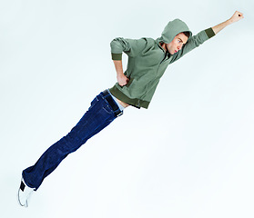 Image showing Man in flying, superhero pose with fashion and stylish streetwear casual clothes isolated on white background. Energy, carefree with young male model is soaring and posing in jeans and hoodie