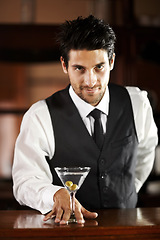 Image showing Man, portrait and giving cocktail at bar for service, drink and welcome to party, club or event. Male server, barman or waiter with glass for alcohol, spirit or mixer with presentation at restaurant
