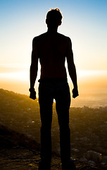 Image showing Man, silhouette and mountain in sunset for achievement, adventure or hiking journey in nature. Male hiker standing on cliff for trekking exercise view, accomplishment or motivation for fitness goals