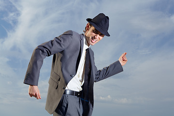 Image showing Business man, dancing and sky with suit, happiness and freedom with success, energy or outdoor for celebration. Young entrepreneur, businessman or dancer with excited face, comic and moving by clouds