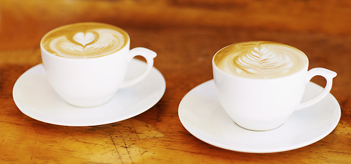 Image showing Latte, retro and coffee cup on brown wooden table at a restaurant to drink expresso in the kitchen. Cafe, coffee and vintage background and espresso aroma with milk and cozy house for breakfast