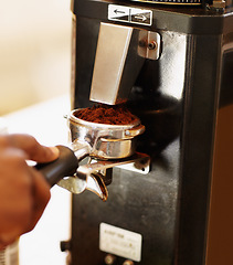 Image showing Hand, coffee grounds and woman barista prepare latte or expresso. Closeup, person working in a restaurant with brewing process and female waiter making a hot drink in a kitchen or cafeteria.