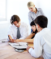 Image showing Collaboration, writing and file with a business team in the boardroom, working together on a project. Teamwork, planning or strategy with men and women employees at work in the office on a project