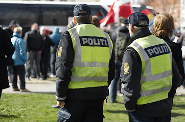 Image showing Law enforcement, safety and crowd control with police officer in city for peace, security or authority. Emergency services, justice and guard with person in Denmark street for rally, order and arrest